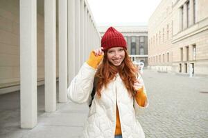 feliz ruiva garota, turista indo por aí cidade, explorando observação lugares dentro cidade, mochilão por aí Europa, goza viajando foto