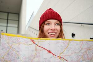 lindo menina turista senta em escadas com cidade mapa, planos dela jornada, parece para direção enquanto viajando por aí cidade, pesquisas rota para passeios turísticos foto