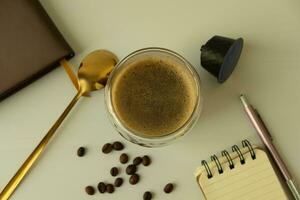 café caneca com crema com café cápsula elementos, café feijões, em uma branco fundo café conceito enquanto trabalhando foto