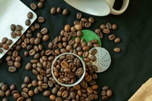 café feijões dentro e por aí uma recarregável café cápsula em uma Preto fundo. foto