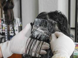cabeleireiro profissional colorindo o cabelo no salão foto
