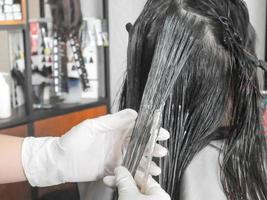 cabeleireiro profissional colorindo o cabelo no salão foto