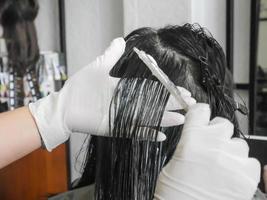 cabeleireiro profissional colorindo o cabelo no salão foto