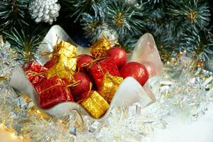 Natal composição com Natal árvore galhos, vermelho bolas em amarelo presentes dentro prata ouropel foto