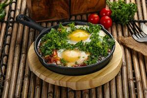 Shakshuka assado ovo dentro a panela com tomate foto