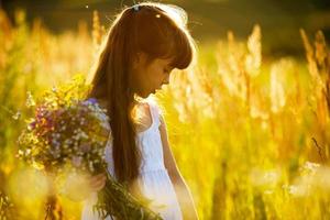 menina com um buquê de flores silvestres foto