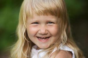 menina loira feliz sorrindo alegremente foto