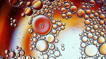 óleo de comida colorida abstrata gotas de bolhas e esferas fluindo na superfície da água foto