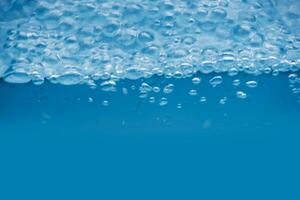 água Azul bolhas em a superfície ondulações. desfocar borrado transparente Branco preto colori Claro calma água superfície textura com respingo e bolhas. água ondas com brilhando padronizar textura fundo. foto