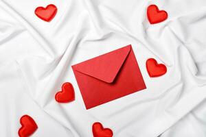 romântico conceito. dia dos namorados dia fundo. vermelho envelope e corações em uma seda Folha foto