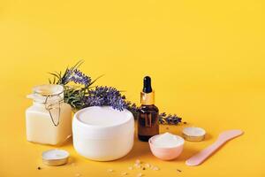 lavanda óleo, creme, esfregar, mascarar e sal em uma amarelo fundo. natural faça você mesmo cosméticos produtos, casa corpo pele Cuidado foto