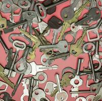 chaves em fundo rosa. chaves de fechaduras e cofres para foto