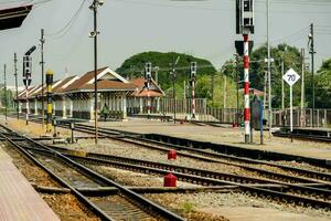 uma trem estação com uma plataforma e faixas foto