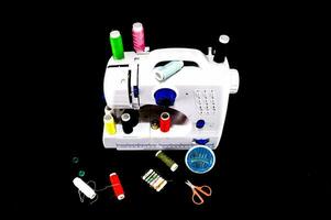uma de costura máquina com vários tipos do fio e agulhas foto
