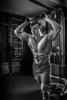 sexy muscular homem posando dentro academia, em forma abdominal. Forte masculino n foto