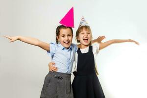 dois aniversário meninas dentro camisa azul escola uniforme vestidos chapéu isolado em branco fundo crianças estúdio retrato. infância crianças Educação estilo de vida conceito. zombar acima cópia de espaço foto