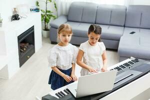casa piano lição. dois meninas prática Folha música em 1 musical instrumento. família conceito. a idéia do Atividades para crianças durante quarentena. foto