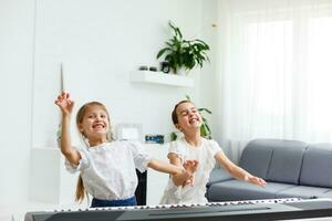 casa piano lição. dois meninas prática Folha música em 1 musical instrumento. família conceito. a idéia do Atividades para crianças durante quarentena. foto