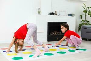 dois pequeno meninas tendo Diversão jogando jogos em chão às lar. irmãos amizade foto