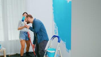 marido e esposa renovando e cantando em pintura escovar. construção, reforma, decoração. casa decoração e renovação dentro acolhedor apartamento plano, reparar e reforma foto