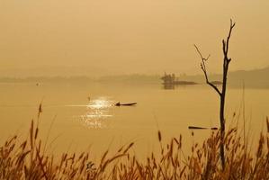 bela vista sombras luz barco de cauda longa nascer do sol no parque nacional da represa srinakarin kanchanaburi, tailândia foto