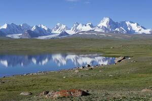 kakshaal também montanhas refletindo dentro a alpino lago, tian Shan montanha alcance perto a chinês fronteira, naryn região, Quirguistão foto