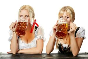 dois lindo mulheres beber Cerveja a partir de ampla óculos enquanto sentado às uma de madeira mesa em uma branco fundo dentro a estúdio foto