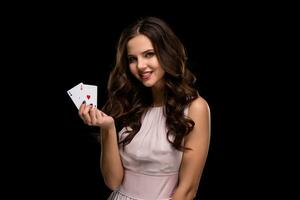 sexy encaracolado cabelo morena posando com salgadinhos dentro dela mãos, pôquer conceito Preto fundo foto