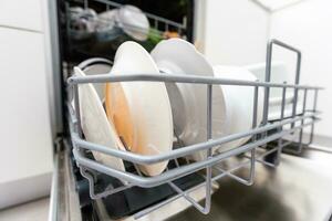 pratos e talheres em lavar pratos máquina. limpar \ limpo pratos. foto