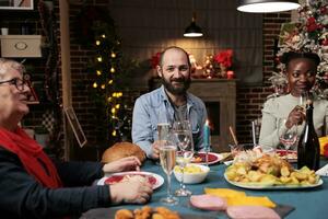 adulto desfrutando inverno natal jantar com diverso amigos, encontro com família perto lareira para comemoro Natal véspera feriado. pessoas tendo Diversão durante festivo tradicional celebração, acolhedor decoração. foto