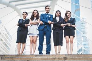 retrato de um grupo bem sucedido de empresários ao ar livre urbano. felizes empresários e empresárias em pé como equipe em um gesto de satisfação. grupo de pessoas bem-sucedido sorrindo e olhando para a câmera foto