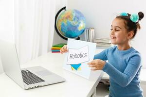 pequeno menina estudando robótica em computador portátil conectados foto