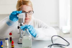 jovem fêmea cientista analisando amostra dentro laboratório foto