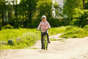 feliz pequeno menina com dela bicicleta foto