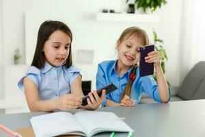 dois pequeno meninas estudando on-line. distância Aprendendo on-line, e-learning, conceito foto