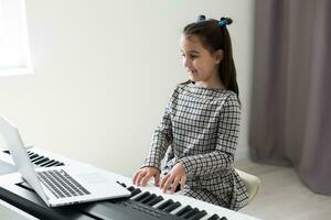 pequeno menina distância Aprendendo a piano conectados durante quarentena. coronavírus conceito. foto