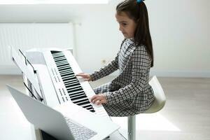 pequeno menina distância Aprendendo a piano conectados durante quarentena. coronavírus conceito. foto