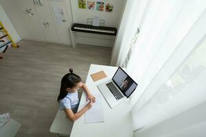 pequeno menina estudando com computador portátil conectados Aprendendo foto