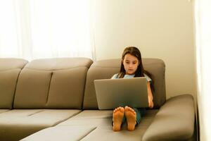 pequeno menina estudando dever de casa matemática durante dela conectados lição às lar, social distância durante quarentena, auto-isolamento cópia de espaço bandeira foto