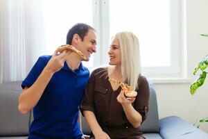 homem e mulher comendo uma pizza e desfrutando a tarde foto