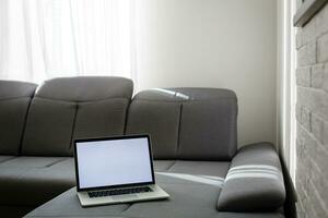 moderno interior. confortável ambiente de trabalho. a computador portátil é em a sofá foto