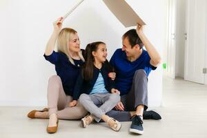 conceito habitação uma jovem família. mãe pai e criança dentro Novo casa com uma cobertura foto
