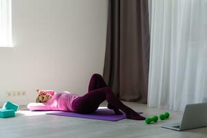 ginástica mulher exercício em a chão às casa foto
