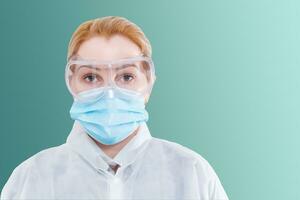 cirurgião mulher dentro protetora óculos e mascarar em brancos fundo. foto