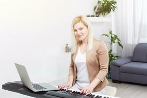 mulher músico jogando clássico digital piano às casa durante conectados classe às lar, social distância durante quarentena, isolamento voluntário, conectados Educação conceito foto