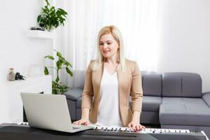 mulher músico jogando clássico digital piano às casa durante conectados classe às lar, social distância durante quarentena, isolamento voluntário, conectados Educação conceito foto