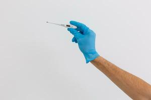mãos dentro azul luvas segurando uma médico termômetro foto
