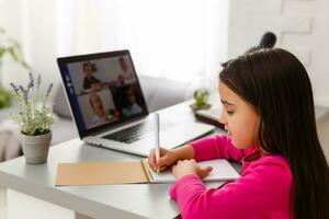 pequeno menina estudando com computador foto