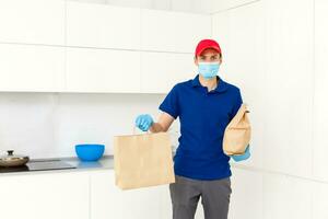 Entrega homem segurando cartão caixas dentro borracha luvas e mascarar. conectados compras e expressar Entrega foto