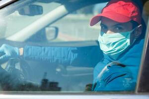 fechar-se fotos do motoristas vestindo máscaras para proteger contra poeira e a espalhar do a gripe. cobiçado 19. dentro a carro frente